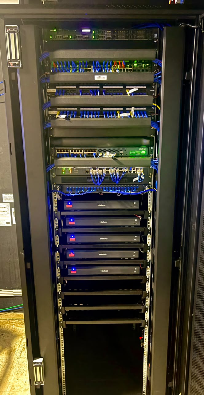Rack com cabeamento azul e equipamentos instalados